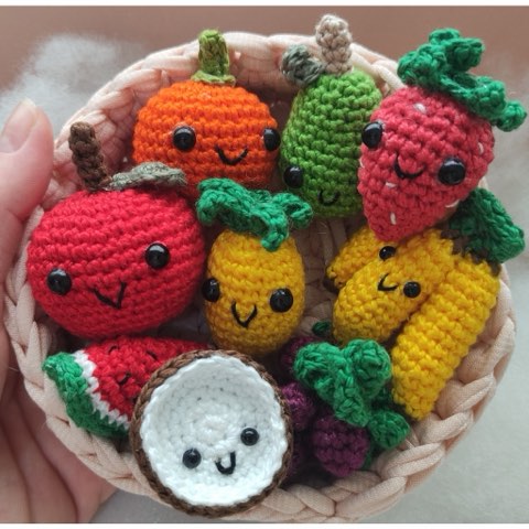 A bowl of smiling crochet fruit with little embroidered faces