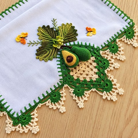 A white dish towel edged with a crochet avocado border