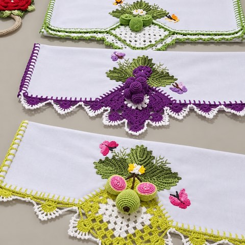 The corner of a towel trimmed with crochet grapes and leaves