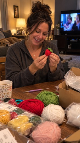 Laura holding up her first finished crochet strawberry